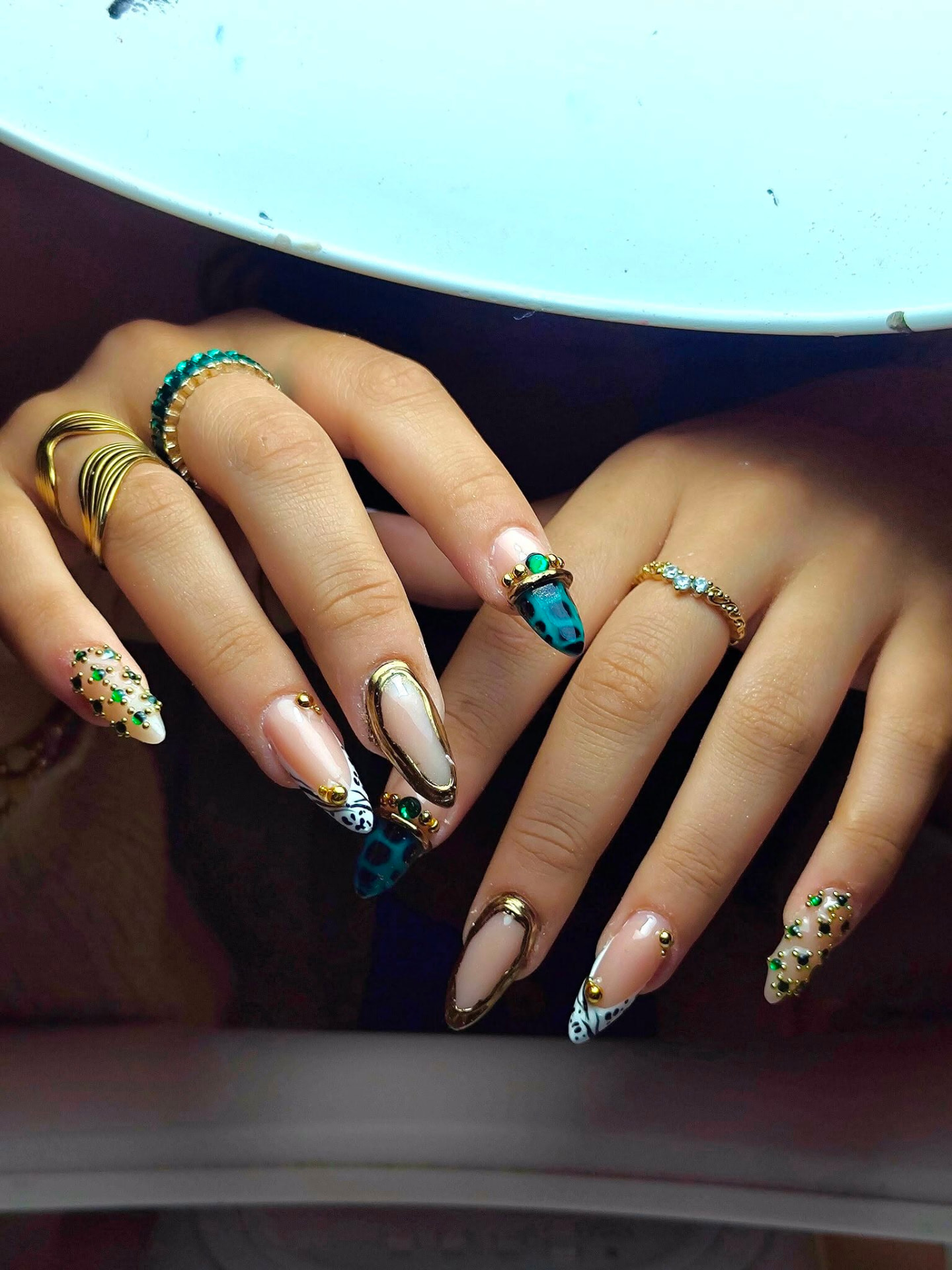 Emerald and gold chrome almond nails with gems
